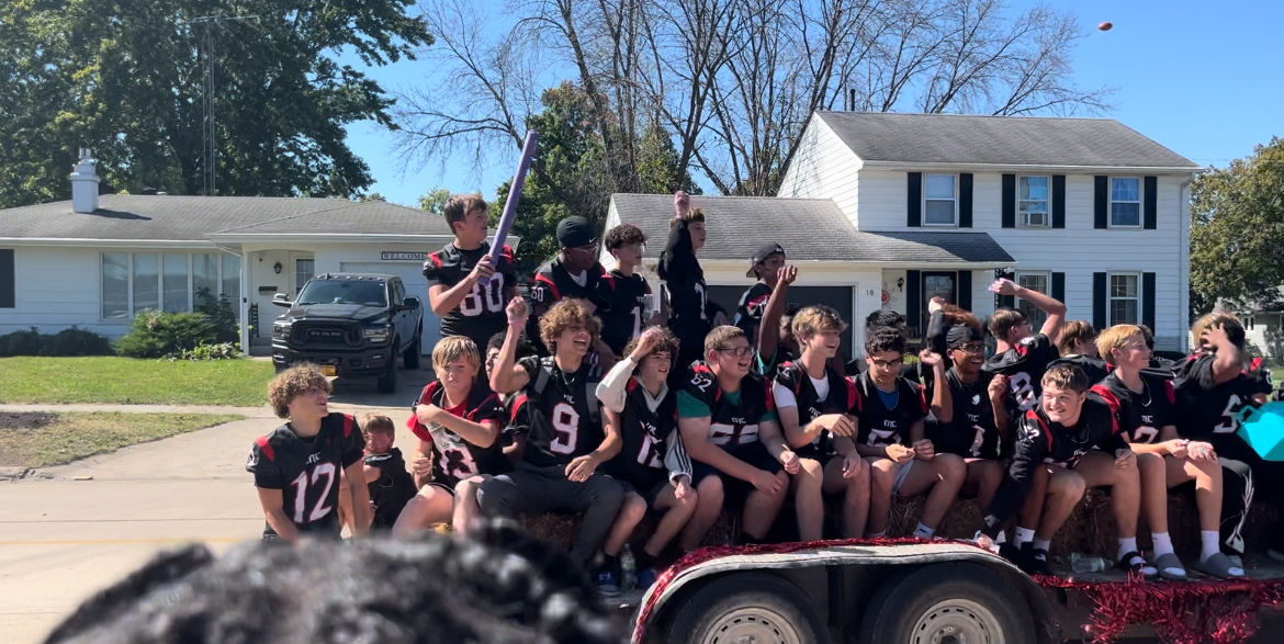 Freshman football players rally with the crowd during the Homecoming parade that led to a community rally in the Downtown Pavillion.