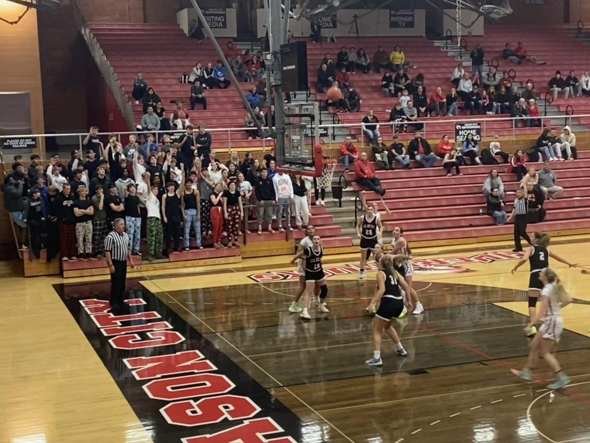 Students at Friday night's game cheer as girls' basketball captain Machaela Trask sinks a three-pointer. 