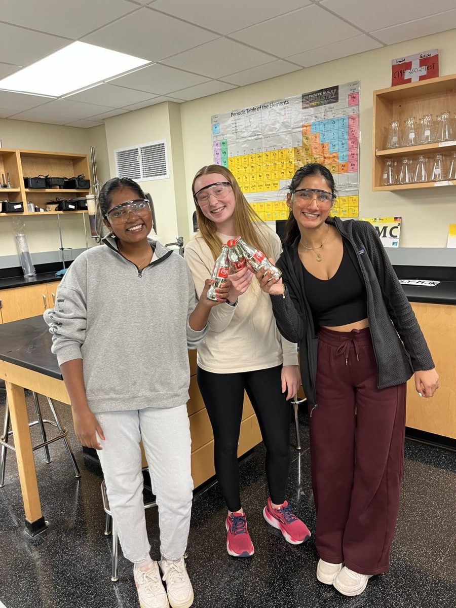 Kaitlyn Thangaraj, Elise Dykstra, and Sofia Ahari pose with their Coke bottles. 