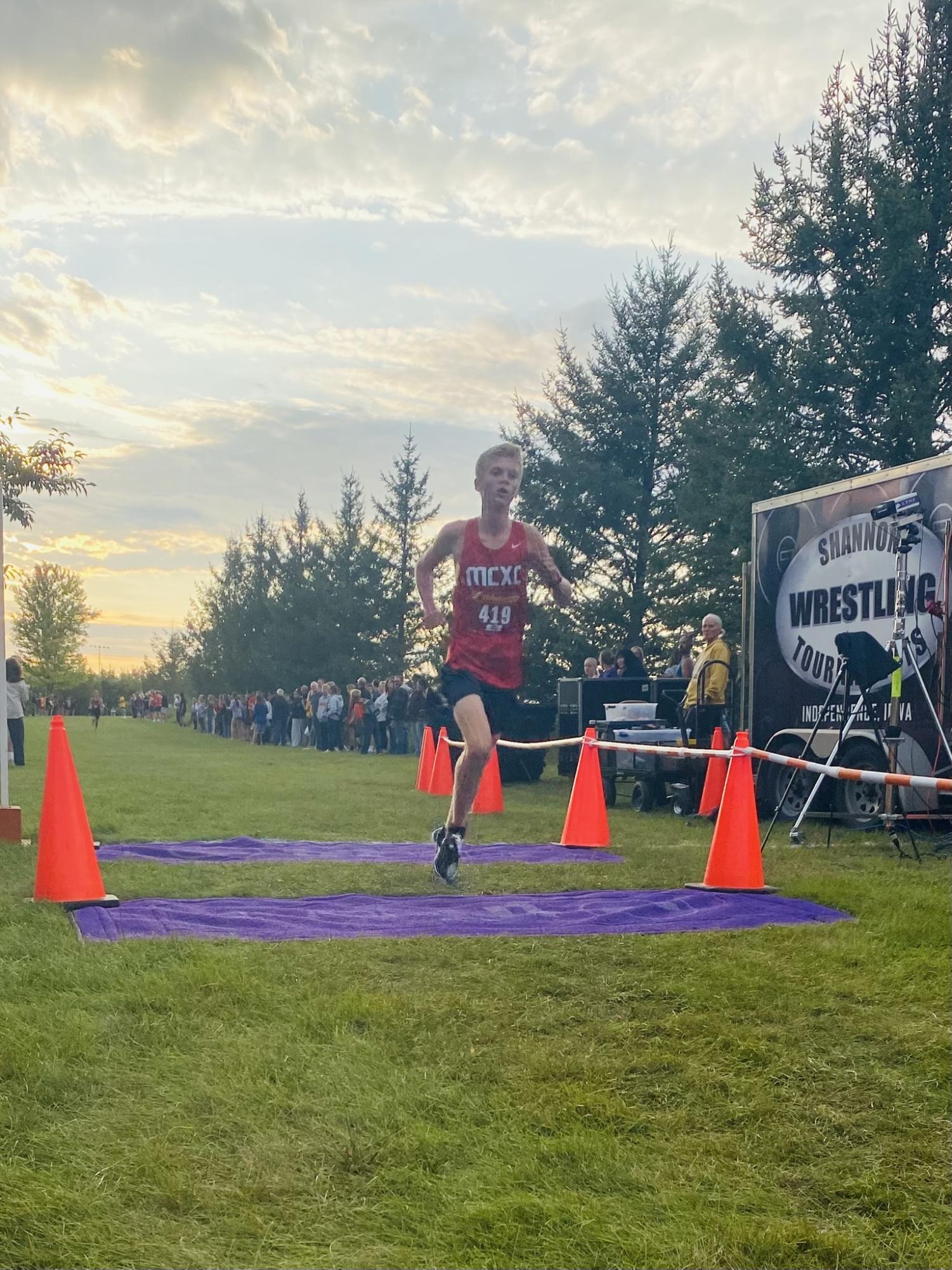 Henry Hansen crosses the finish line at the Wartburg cross country course. 