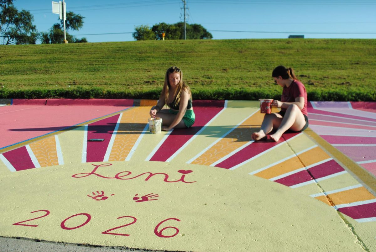 Senior Leni Angell and cousin Mia Francis, a 2016 MCHS graduate, paint on the final details to Angell's parking space Sept. 1. The entire project took two days to complete. 