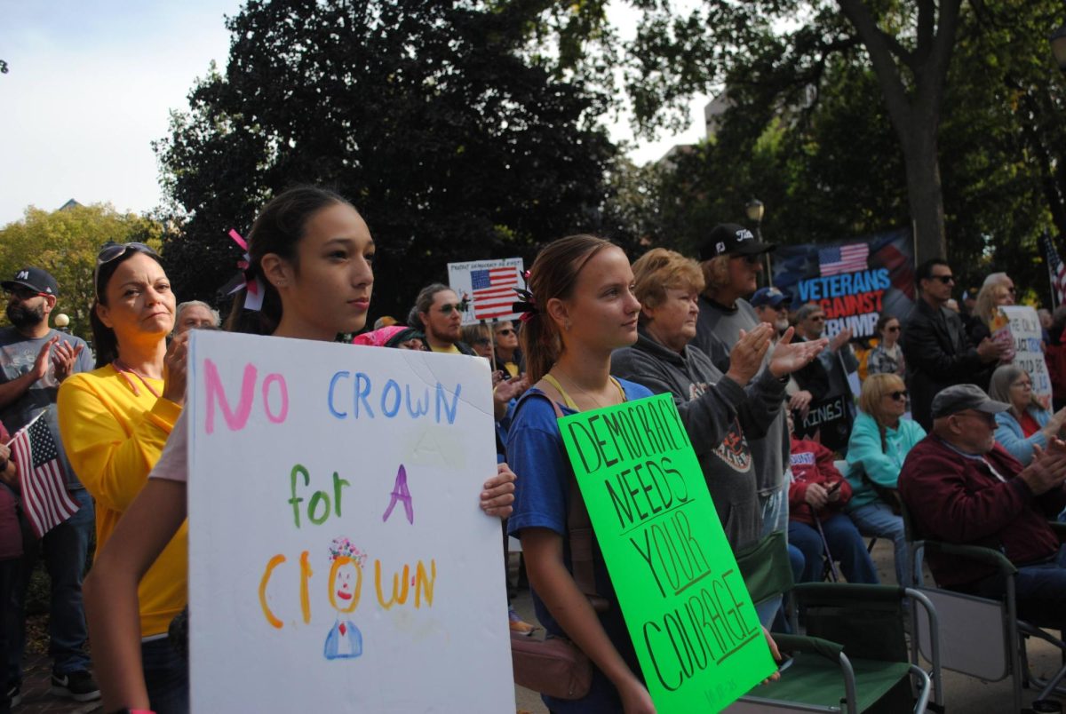 Penelope Scott and Myah Reindl, both freshmen at MCHS, stand with signs and listen to the keynote speakers at the No Kings Protest in Central Park Oct. 18.