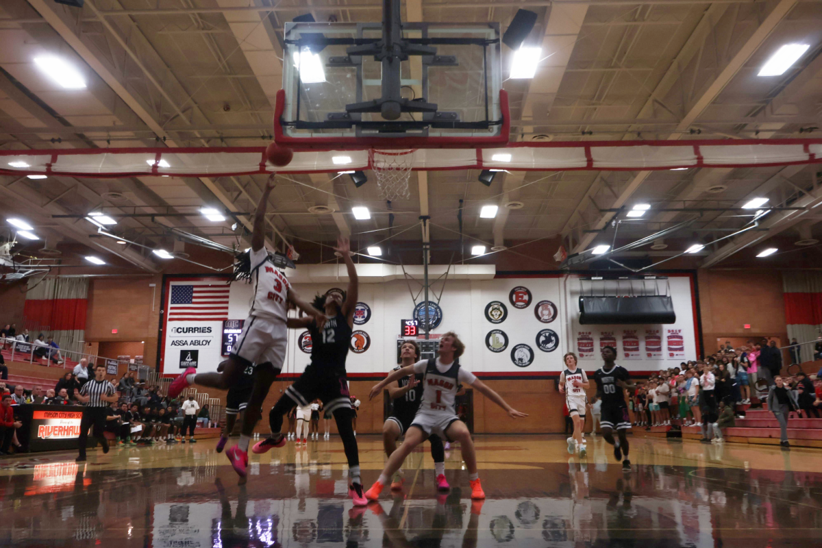 Marcele Whitner goes in for a layup while Drew Hobart boxes out a North player. 
