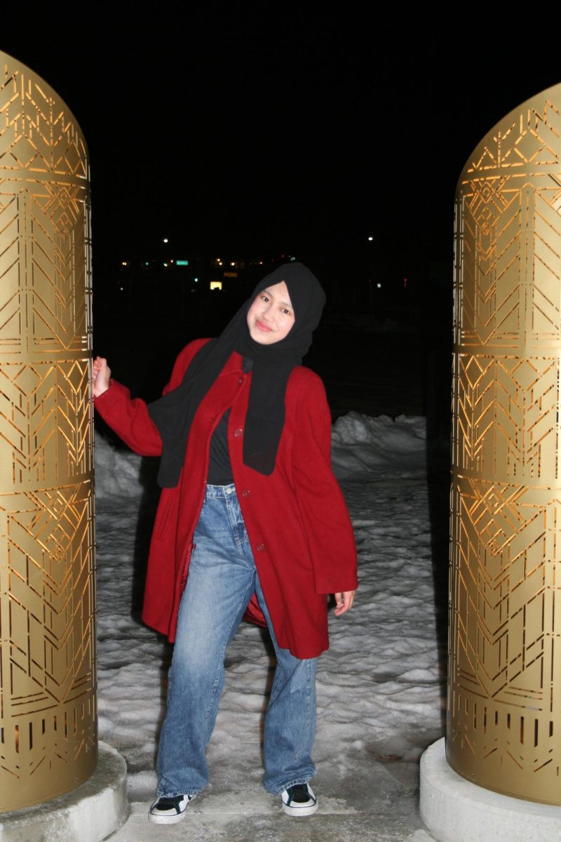 Alfira stands at the Harmony of Lights sculpture in Mason City. The senior is attending Mason City High School as an exchange student from Indonesia during 2025-26.