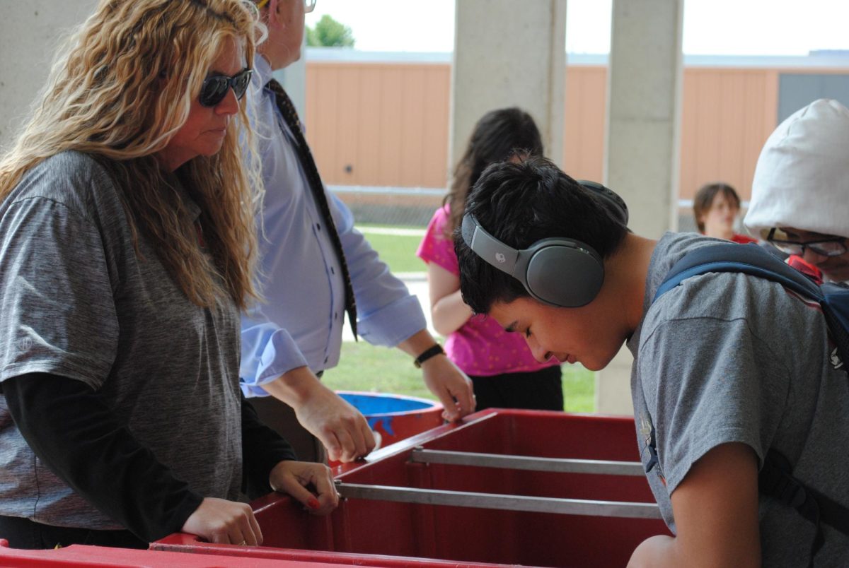 Student Alfredo Torres is looking through the ice cream cooler behind the Riverhawk Stadium. 