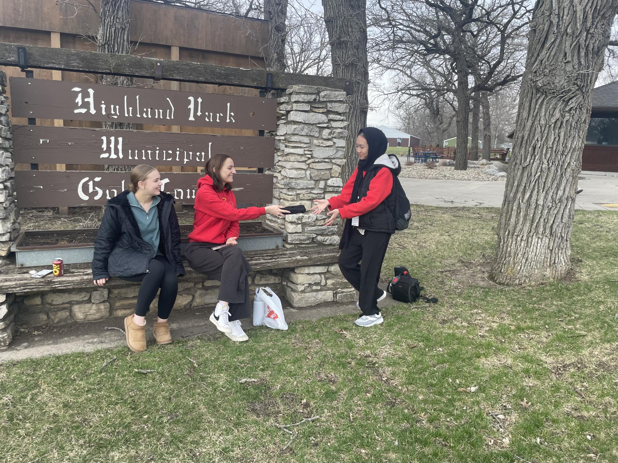 MCHS students Merin Teeter and Sarah Schutt hand out free t-shirts to Alfira and others at the Highland Golf Course. Alfira is on an exchange program bridging relations between the U.S. and countries with significant Muslim populations. 